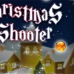 Karlı bir köy manzarasının önünde, Noel temalı dekoratif toplar ve parıltılı yazı bulunuyor