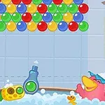 Banyo küvetinde köpükler arasında mutlu görünen renkli kuşlar ve üst kısımda kırmızı, yeşil, mavi, sarı bilyeler
